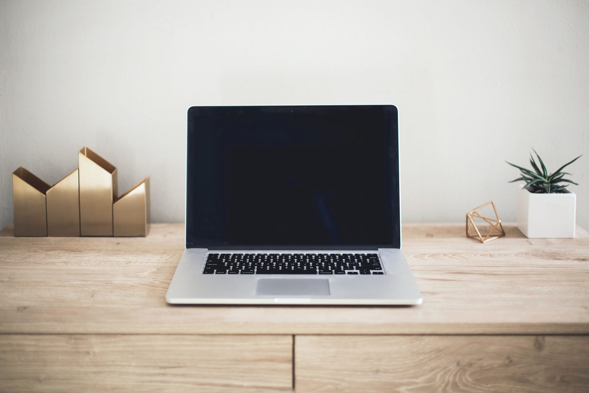 Srebrny laptop na drewnianym biurku do pracy