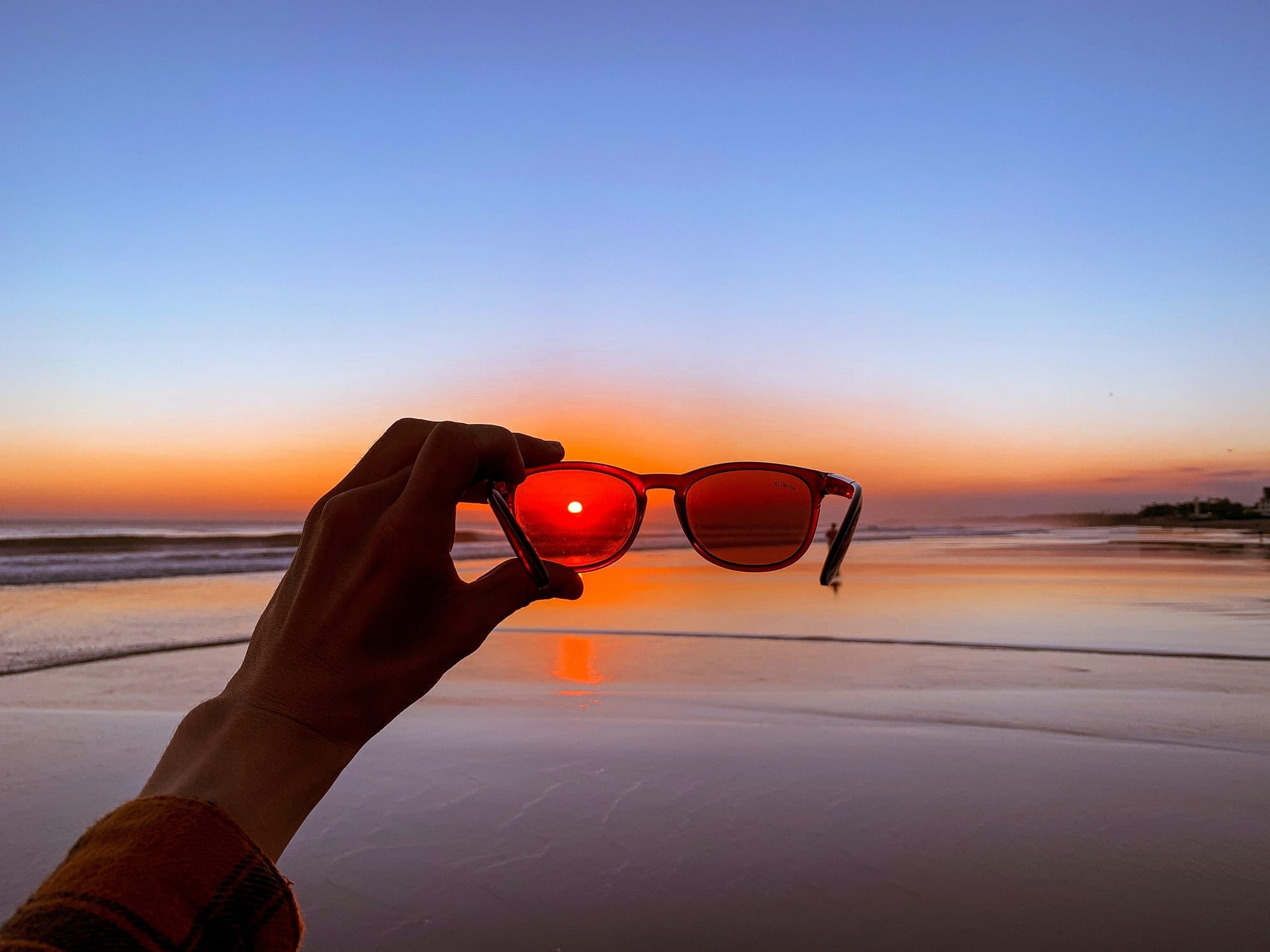 Zachód słońca nad morzem widziany przez okulary przeciwsłoneczne