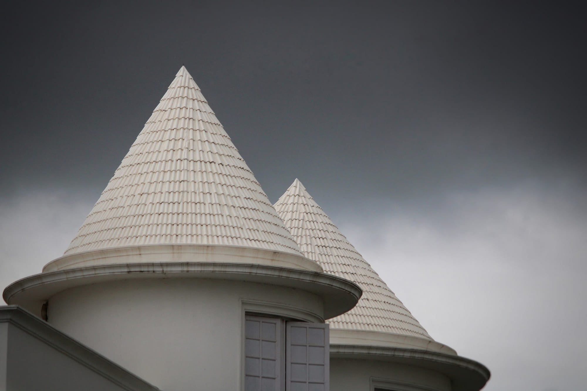 Okrągłe domki z białym dachem na pochmurnym tle